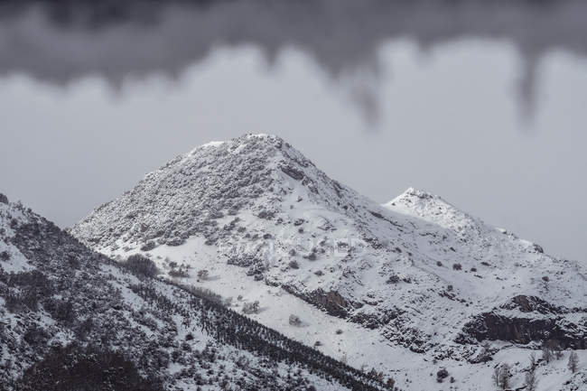 Montanhas cobertas de neve e gelo em uma paisagem nebulosa no norte da Espanha — Fotografia de Stock