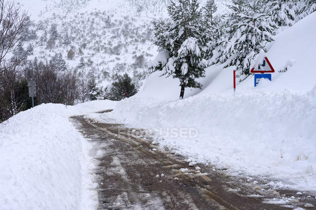 Route d'hiver et panneaux avec neige dans le nord de l'Espagne Montagnes — Photo de stock