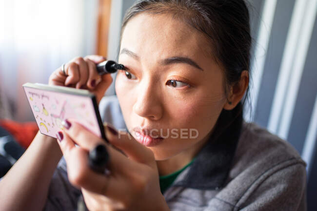 Woman applying mascara on eyelashes — Stock Photo