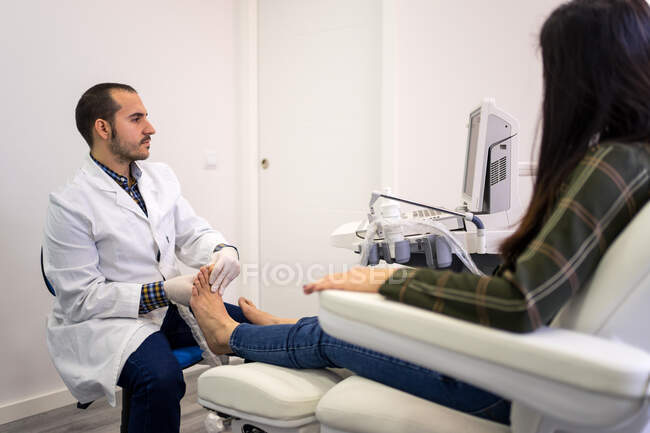 Médico de podología usando escáner de ultrasonido - foto de stock