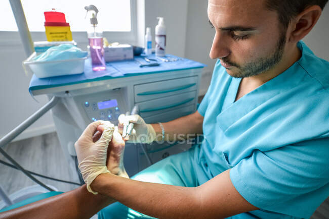Podólogo fazendo procedimento com o paciente — Fotografia de Stock
