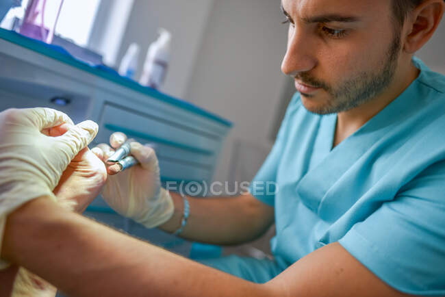 Podólogo fazendo procedimento com o paciente — Fotografia de Stock