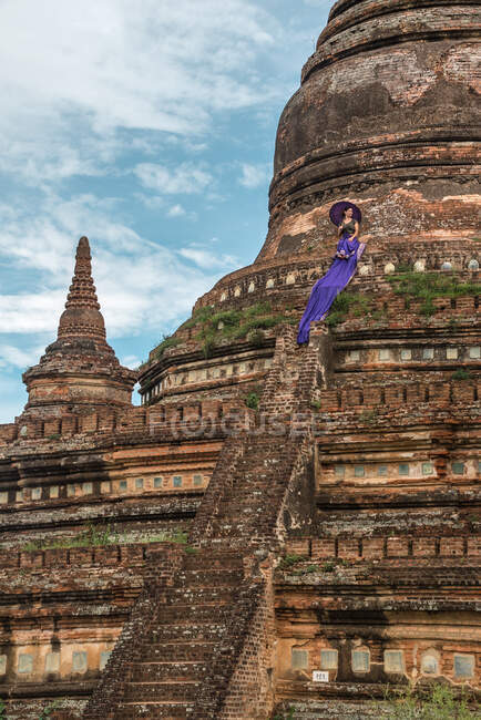 Mujer de pie en las escaleras del antiguo templo budista - foto de stock