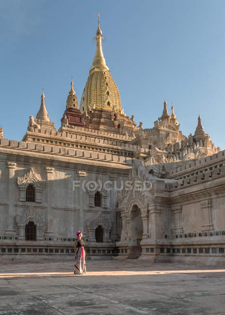 Жінка-туристка стоїть у дворі старого кам'яного храму — стокове фото