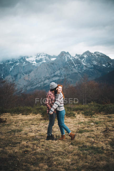 Seitenansicht eines zarten Paares, das sich an kalten Tagen in den Bergen mit geschlossenen Augen umarmt und klebt — Stockfoto