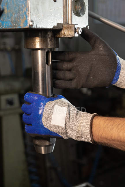Mãos enluvadas do capataz que trabalha no equipamento com válvula na fábrica — Fotografia de Stock