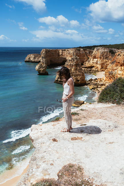 Unerkennbare Frau steht auf Klippe in Meeresnähe — Stockfoto