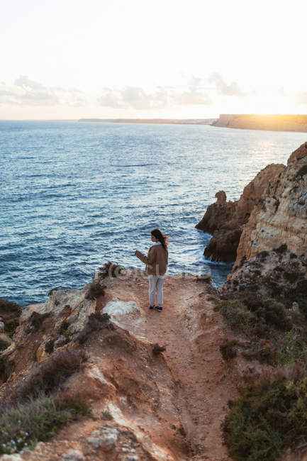 Femme méconnaissable marchant sur la falaise — Photo de stock