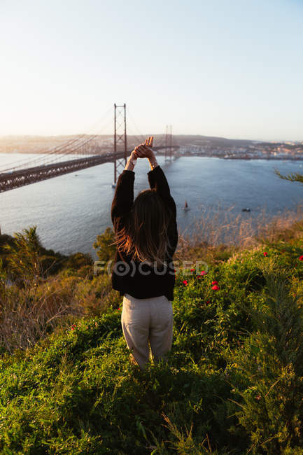 Невідома жінка захоплюється мостом над річкою — стокове фото