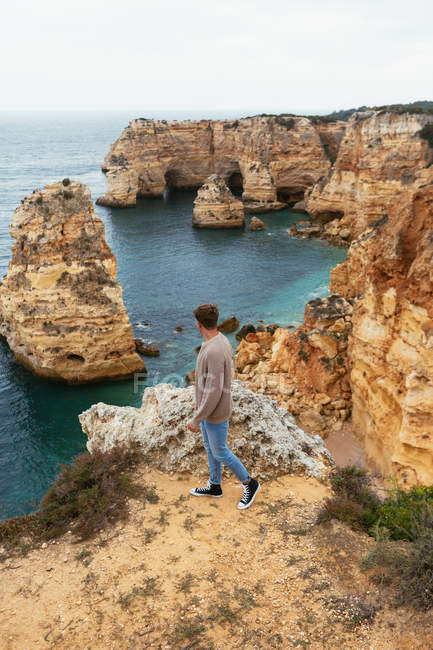 Людина на скелі біля моря — стокове фото
