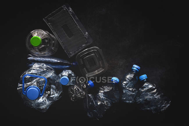 Ansicht von Plastikflaschen und Schachteln auf dunkler Hintergrundoberfläche — Stockfoto