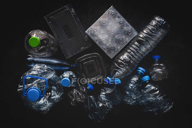 Ansicht von Plastikflaschen und Schachteln auf dunkler Hintergrundoberfläche — Stockfoto