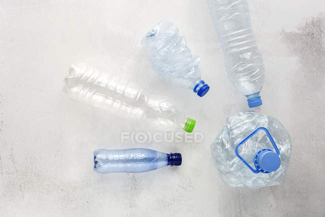 Vista superior de garrafas de plástico e caixas dispostas na superfície de fundo branco — Fotografia de Stock
