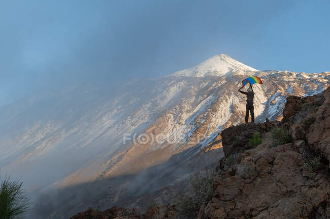 Persona sulla cima della montagna che sventola bandiera LGBT — Foto stock