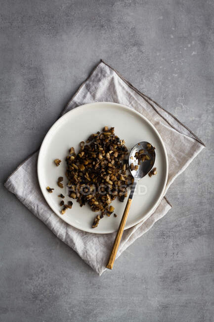 Сверху тарелка с вареной гречкой и ложкой, помещенной на салфетку во время приготовления запеченного сладкого картофельного салата — стоковое фото