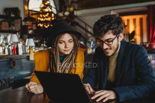 Mulher elegante e homem trabalhando no laptop no café — Fotografia de Stock