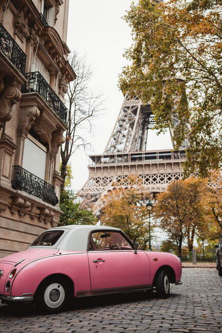 From below Eiffel Tower and pink antique car in street of France in fall — Stock Photo