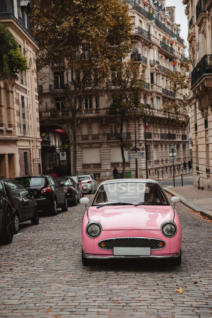 Pink retro car parked on old town street in Paris, France on gloomy autumn day — Stock Photo