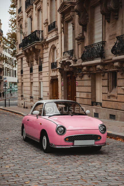 Pink retro car parked on old town street in Paris, France on gloomy autumn day — Stock Photo