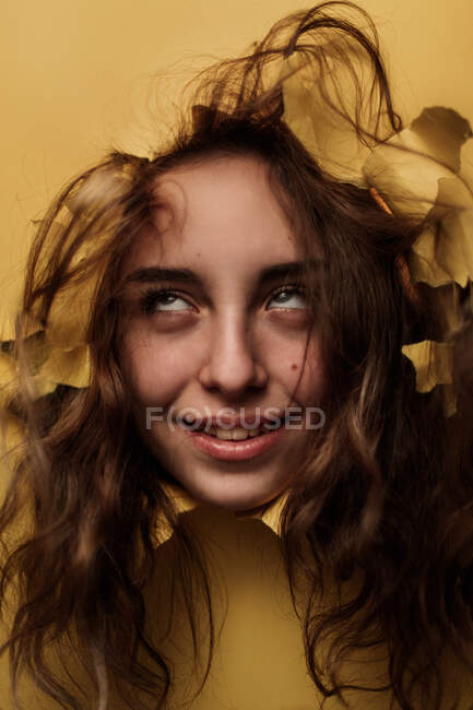Nachdenklich weiblich teenager looking out aus loch im studio — Stockfoto
