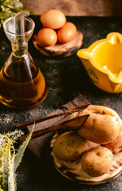 From above of table with oil and eggs and potatoes for food making in kitchen — Stock Photo