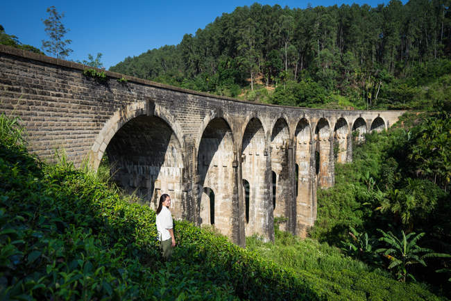 Jeune femme appréciant le paysage de pont antique — Photo de stock