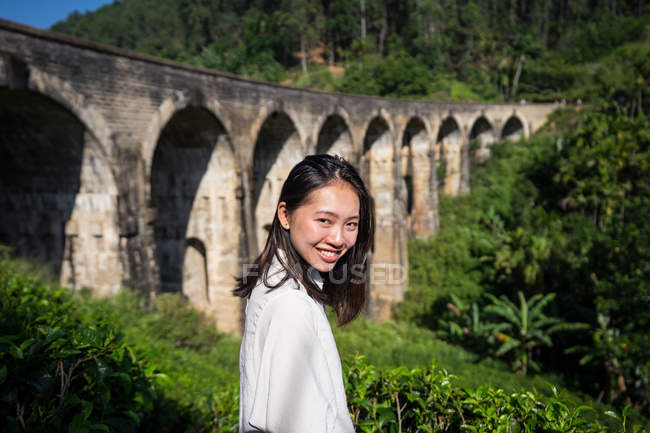 Jeune femme appréciant le paysage de pont antique — Photo de stock