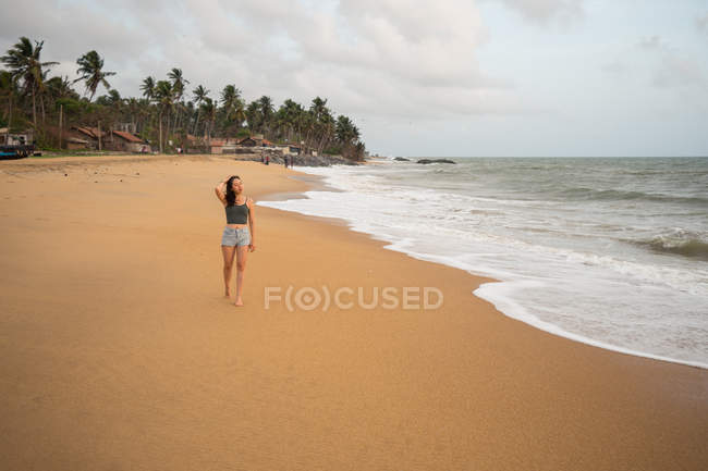 Mujer pacífica en la playa solitaria - foto de stock