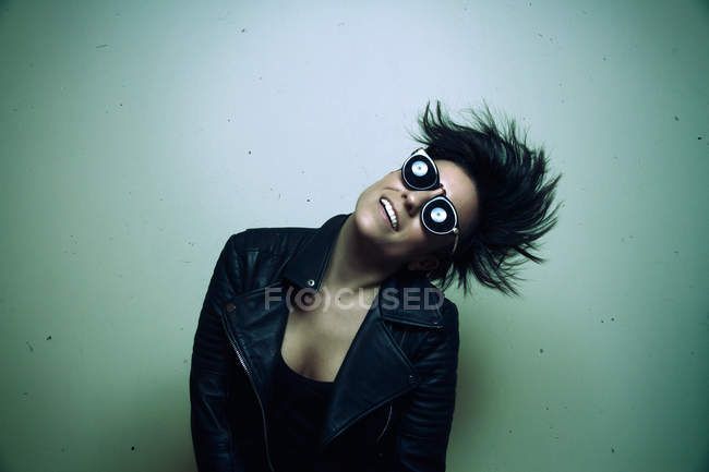 Strong young female rocker in leather jacket in studio — Stock Photo