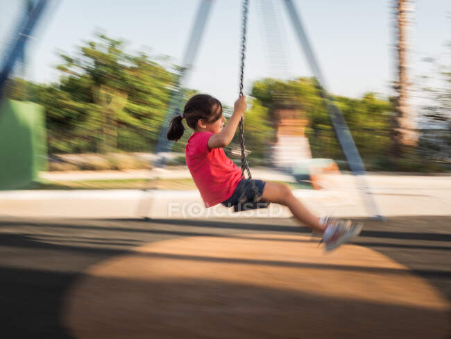 Chica en swing en el parque - foto de stock