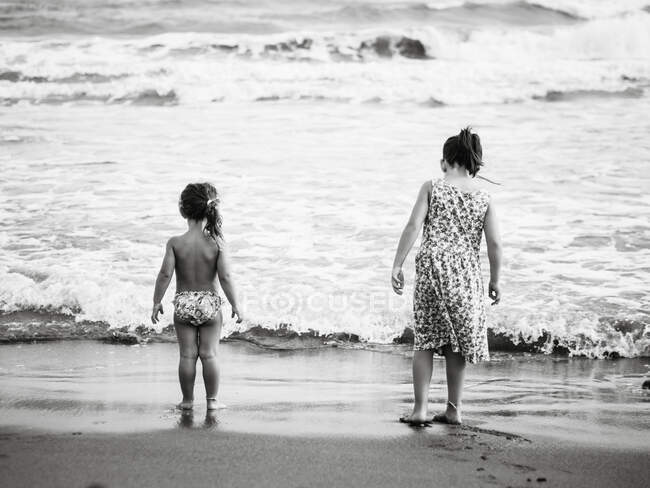 Irmãs anônimas perto do mar acenando — Fotografia de Stock