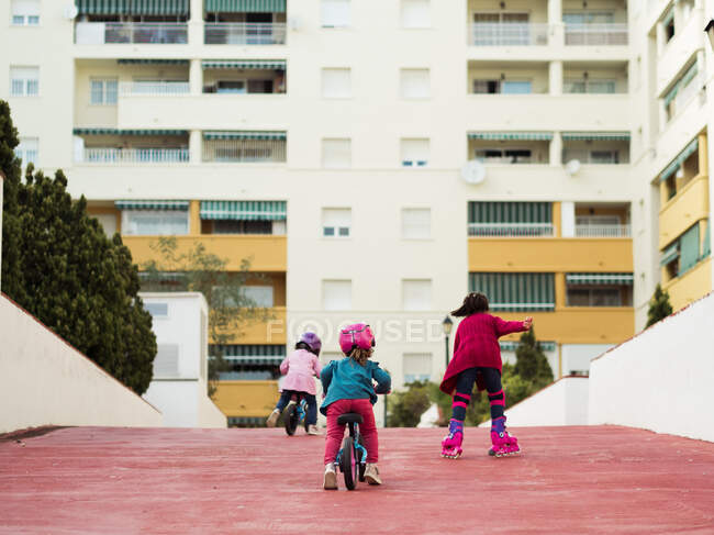 Дети катаются на велосипедах и роликах вместе — стоковое фото