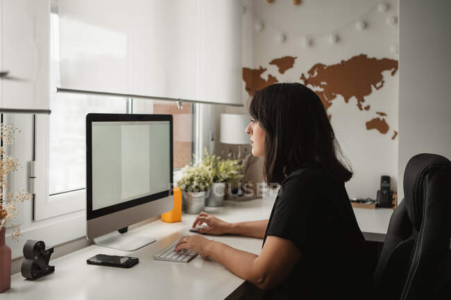 Empresária focada usando computador desktop no escritório — Fotografia de Stock