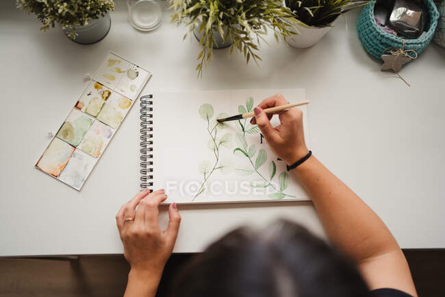 Безликая художница рисует акварелью дома — стоковое фото