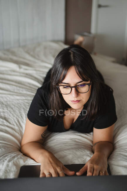 Обманутая молодая студентка использовала ноутбук на кровати дома — стоковое фото
