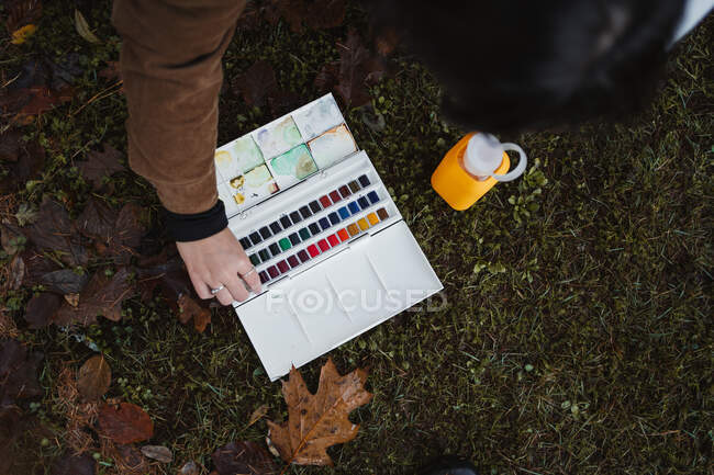 Mujer con pinturas de acuarela en bosque de otoño - foto de stock