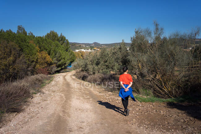 Азиатская женщина, идущая по дороге в сельской местности — стоковое фото