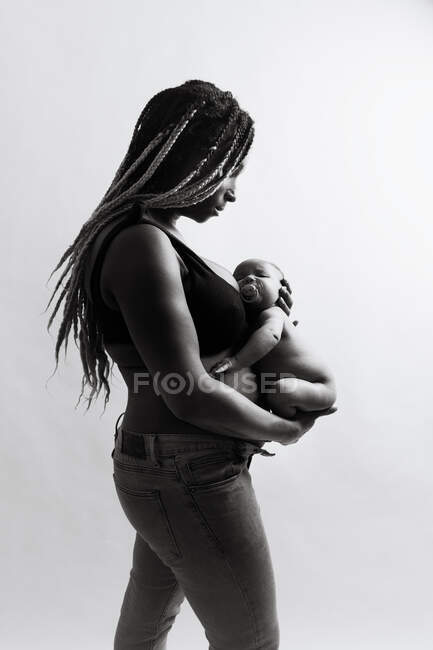 Mujer afroamericana sosteniendo bebé recién nacido - foto de stock