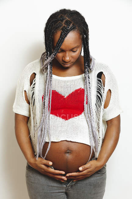 Щаслива афроамериканська вагітна жінка, яка тримається за руки — стокове фото