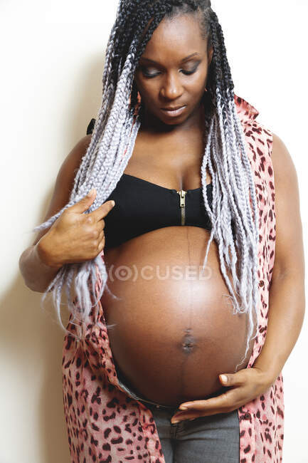 Happy African American pregnant woman holding hands on belly — Stock Photo