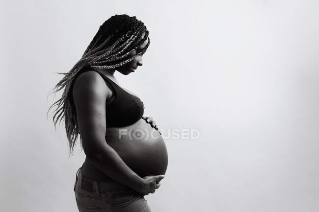 Felice donna afro-americana incinta che si tiene per mano sulla pancia — Foto stock
