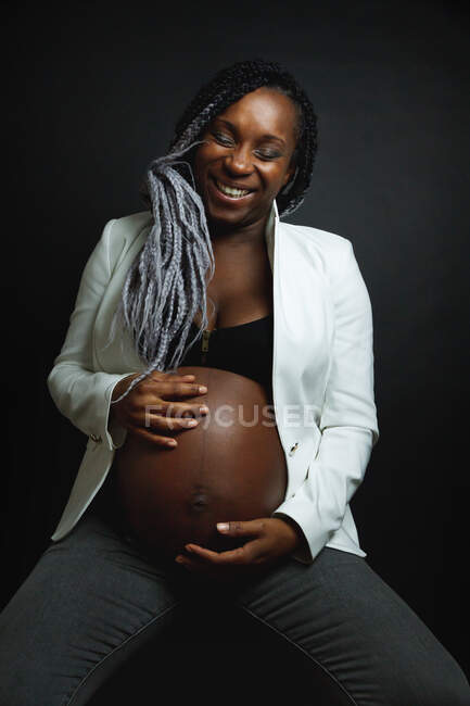 Афроамериканская беременная женщина касается живота — стоковое фото
