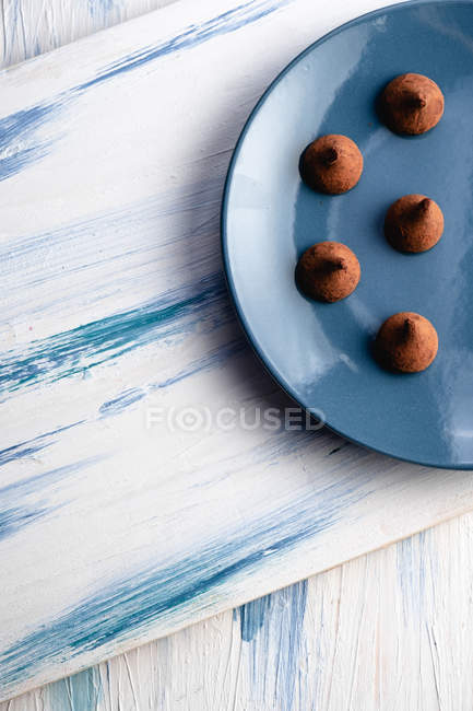 Placa con sabrosas trufas de chocolate en la mesa — Stock Photo