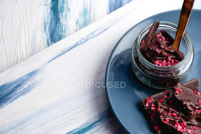 From above delicious pieces of homemade chocolate with marmalade in jar and on plate on wooden rustic table — Stock Photo