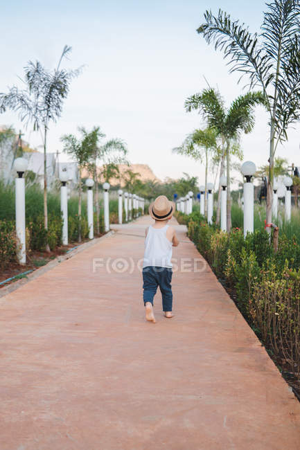 Asiático niño caminando descalzo en calle - foto de stock