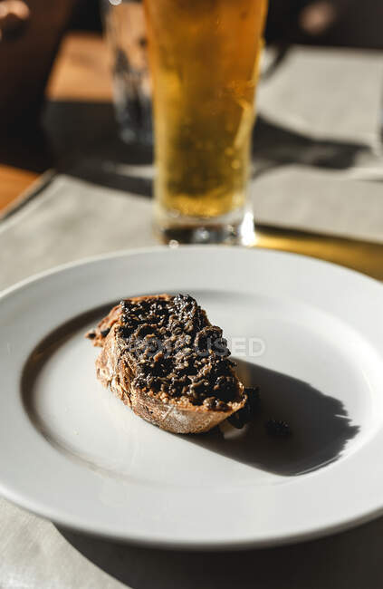 Открытый сэндвич с коричневым соусом на тарелке — стоковое фото