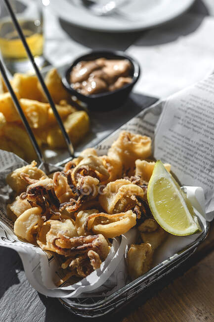 Bowl with fried molluscs with lemon in restaurant — Stock Photo