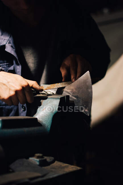 Crop craftsman checking axe in workshop — Stock Photo