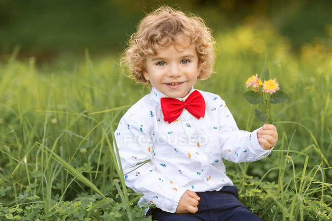 Niño varón muy alegre divirtiéndose en el parque verde - foto de stock
