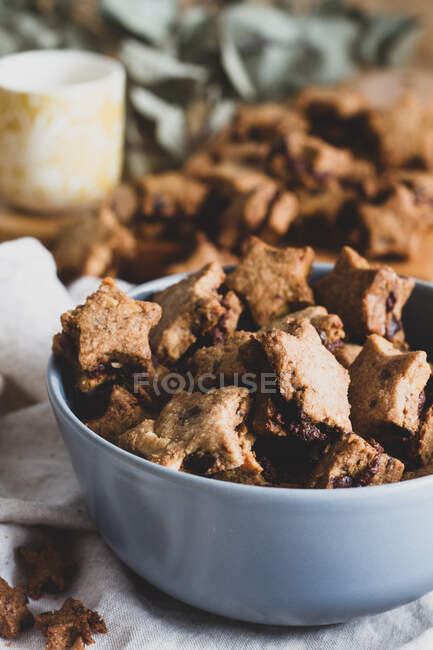 Сверху вкусное коричневое печенье в виде звезды, собранной в миске для чаепития — стоковое фото